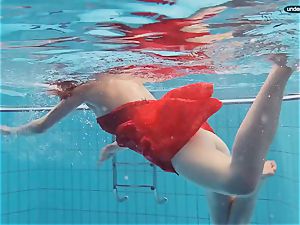 crimson clad nubile swimming with her eyes opened